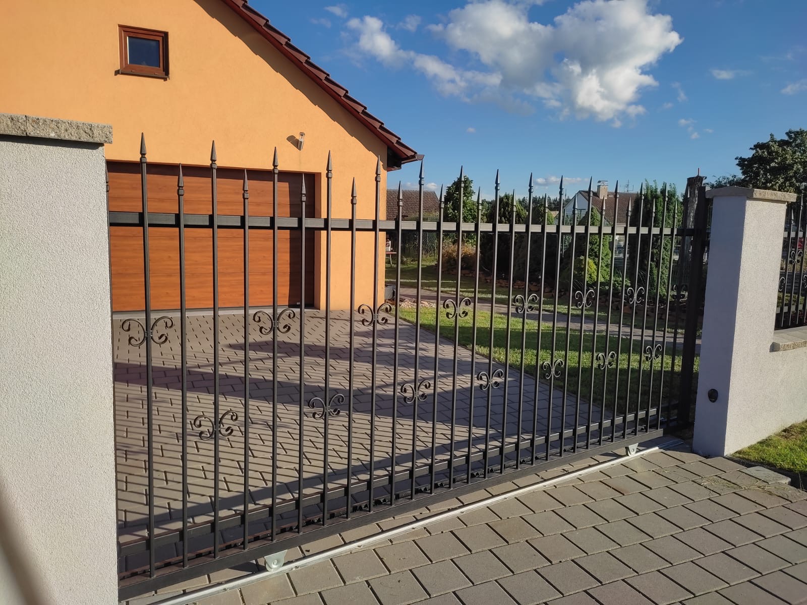 Posuvná brána s ručním kováním u rodinného domu