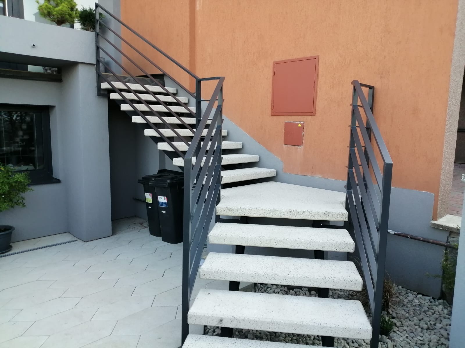 Venkovní kovové schodiště s šedým zábradlím